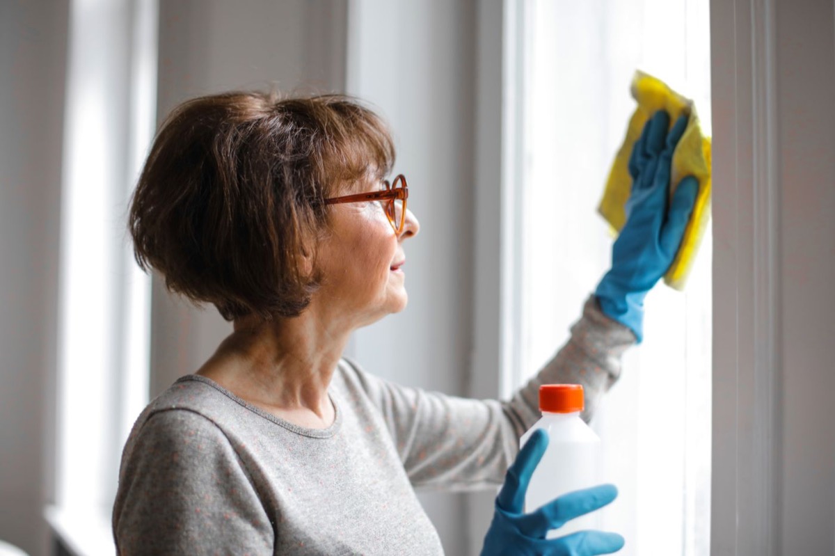 Someone cleaning a window at home on a bright morning